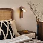 Modern wall sconce for bedroom, Coolilumi rotatable wood and travertine lamp beside bed.
