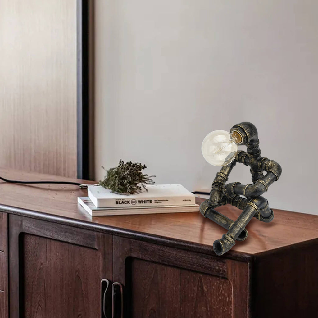 Bronze Pipe Robot Table Lamp on Wooden Console Table with Books & Dried Plant | Industrial Steampunk Decor for Living Room, Entryway or Modern Home Office